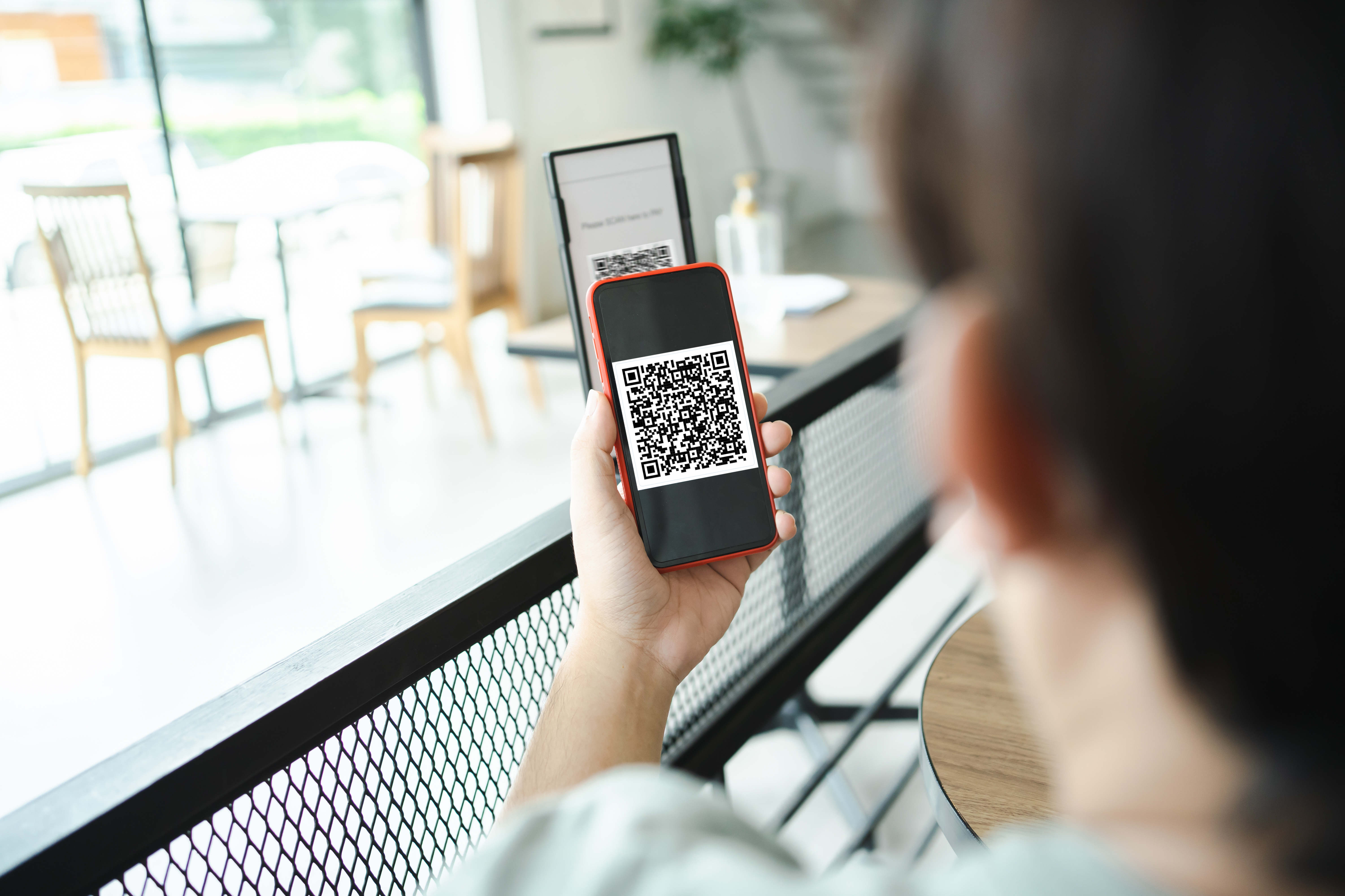 Customer scanning QR code on a table tent to access campaign